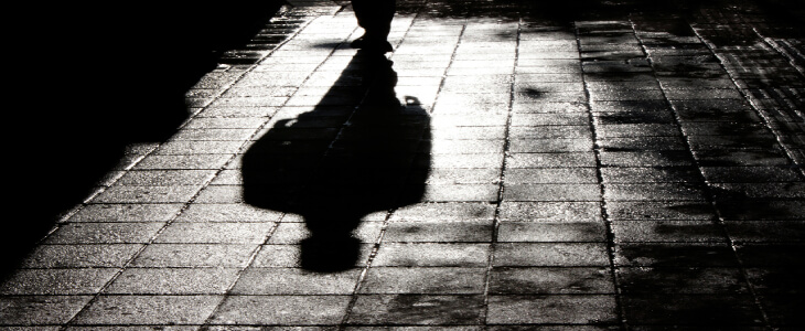 shadow of a person walking through cobblestoned streetsFraud